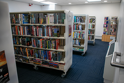 A photo of book cases at Ballynahinch Library stacked with books