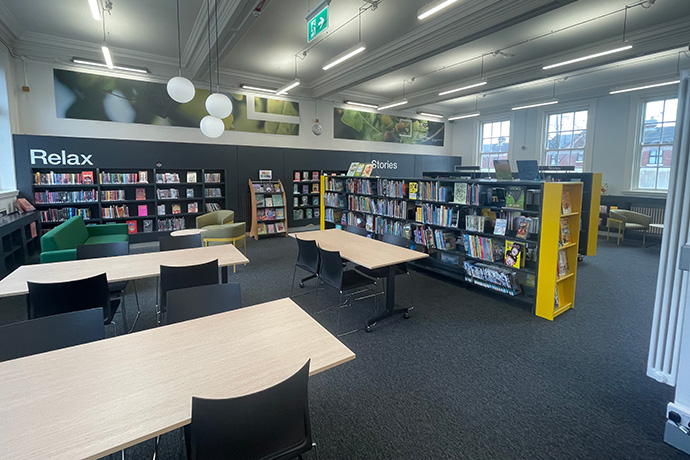 Falls Road Library interior - packed bookshelves and tables for studying at in contemporary surroundings
