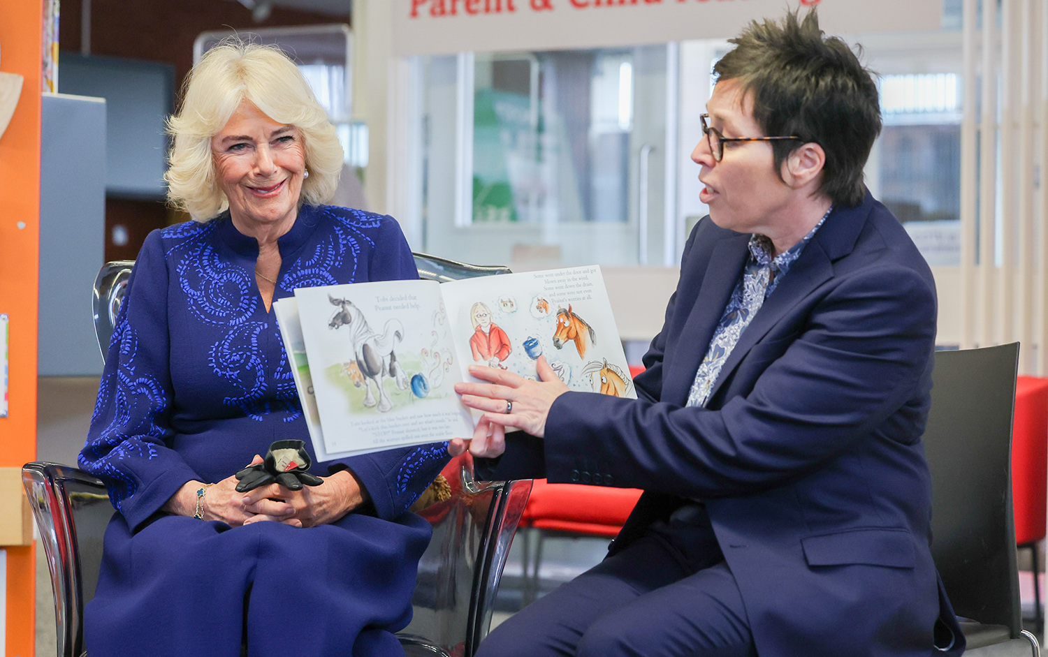 Her Majesty The Queen listens in to a lively Storytime session featuring Peanut Gets His Sparkle Back read by Banbridge Library Assistant Jacqui Torrens and shared with pupils from Abercorn Primary School during her visit to Banbridge Library