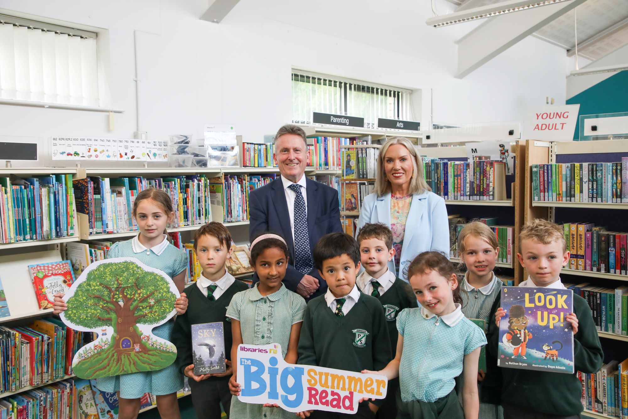 Photo of Pupils from Finaghy Primary School celebrate the beginning of the 2026 Big Summer Read with Libraries NI Chief Executive Jim O'Hagan and Education Authority Chief Education Officer Eve Bremner in Finaghy Library.