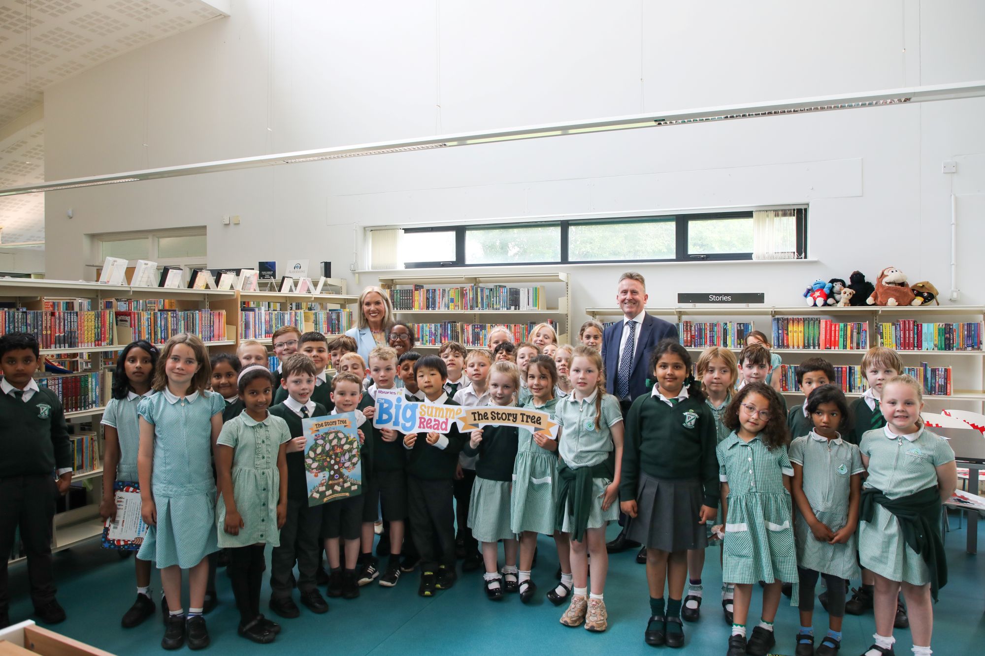 Libraries NI Chief Executive Jim O'Hagan and Education Authority Chief Education Officer Eve Bremner join pupils from Finaghy Primary School in Finaghy Library to mark the beginning of the 2026 Big Summer Read.