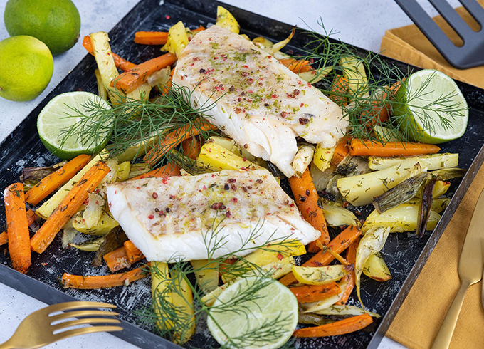 Feature tile which is a photo of a baking tray with fish and vegetables which are about to go into the oven