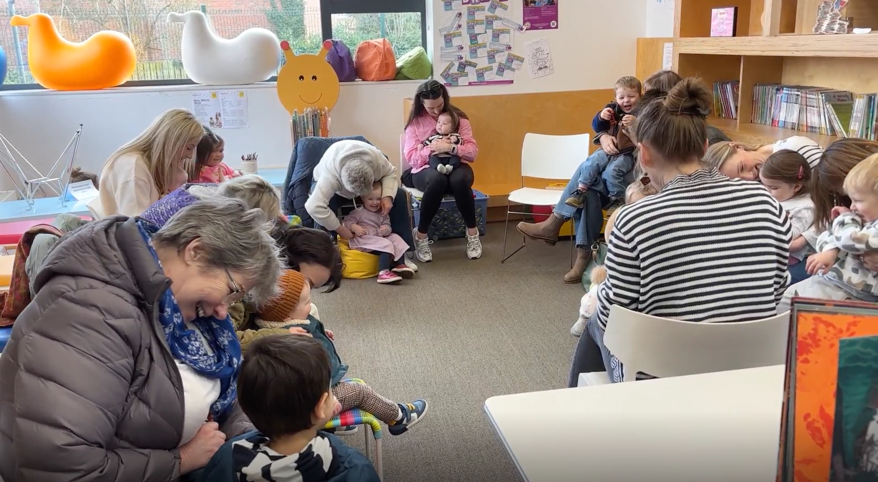 Photo of children in the library with their parents and carers; the next Generation of Readers