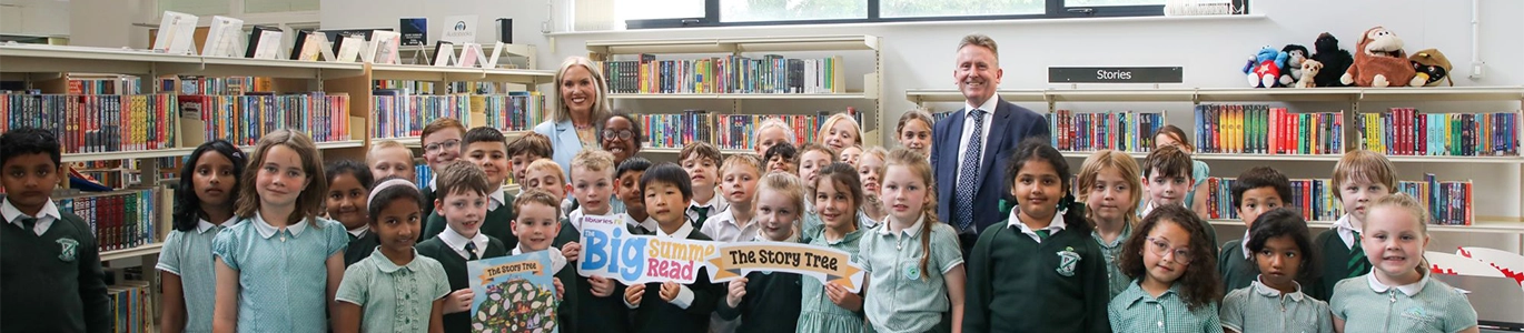 Photo of Libraries NI Chief Executive Jim O'Hagan and Education Authority Chief Education Officer Eve Bremner join pupils from Finaghy Primary School in Finaghy Library to mark the beginning of the 2026 Big Summer Read.