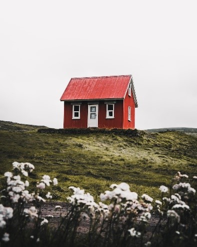 a red house surrounded by grass