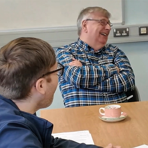 Photo of Frank, a regular member of the Read Aloud Group in Ballymena Central Library with Libraries NI District Officer Daniel