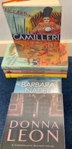 A stack of books including Riccardino by Andrea Camilleri and Donna Leon by Barbara Nadel